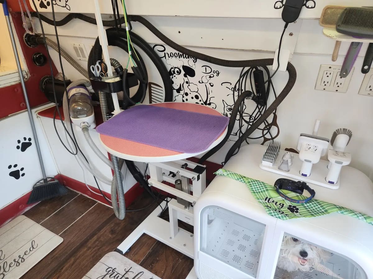 Mobile dog grooming workspace with grooming table and professional tools